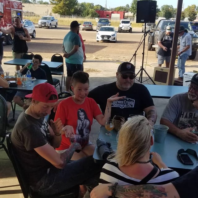 Guests sharing conversation around tables on the patio