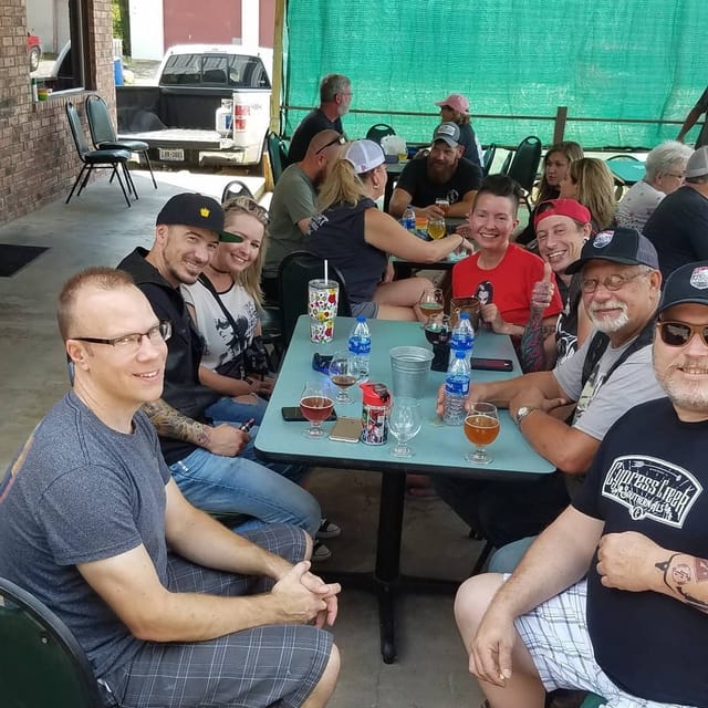 Friends gathered around a table on the brewery patio