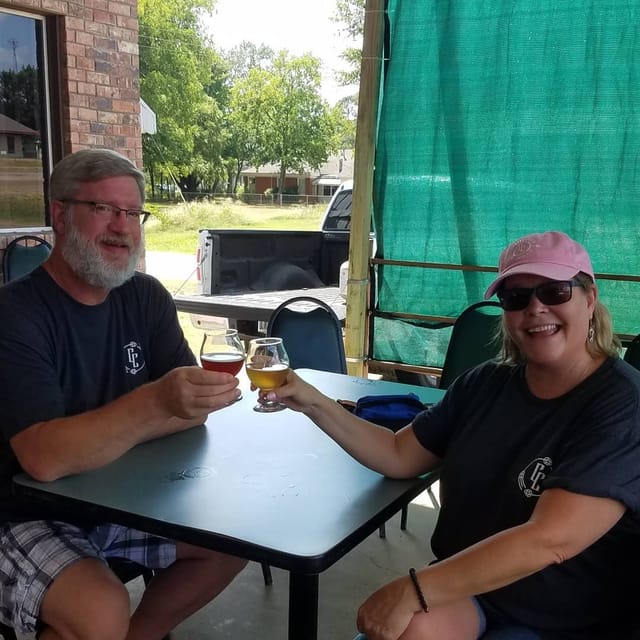 Two guests raising their beer glasses on the patio